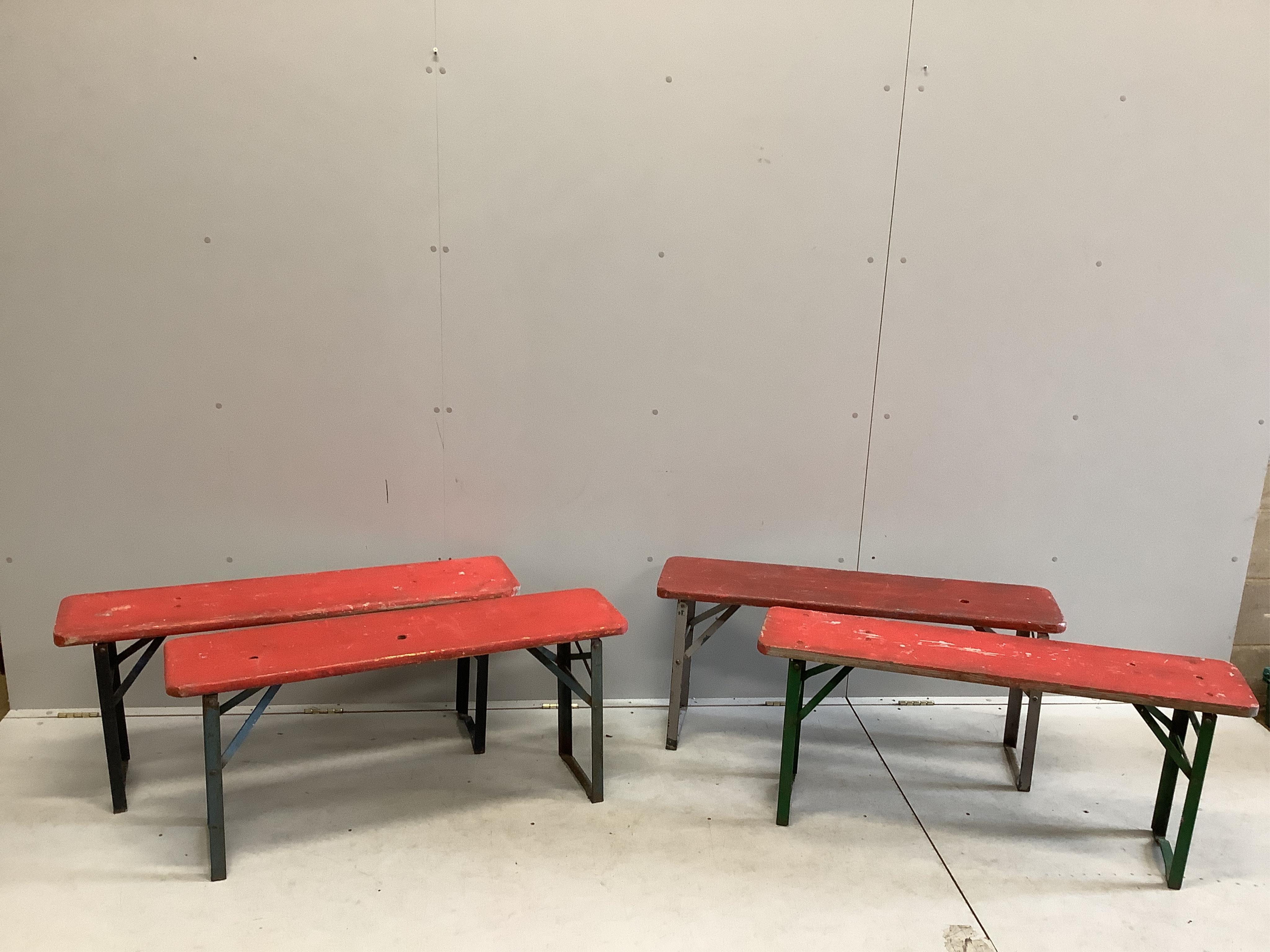 Two folding tables, width 103cm, depth 50cm, height 77cm, together with four red painted benches, with folding iron underframes. Condition - poor to fair